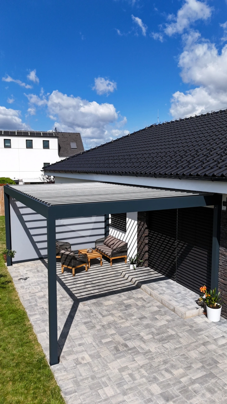 Moderní pergola Rolrols na terase rodinného domu – ukázka stínicí techniky s hliníkovou konstrukcí a venkovním posezením