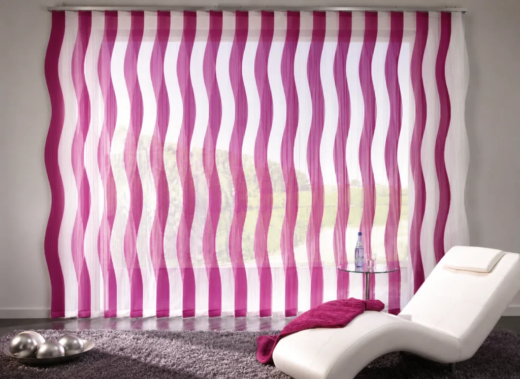 Vertikální žaluzie s designově tvarovanými lamelami.