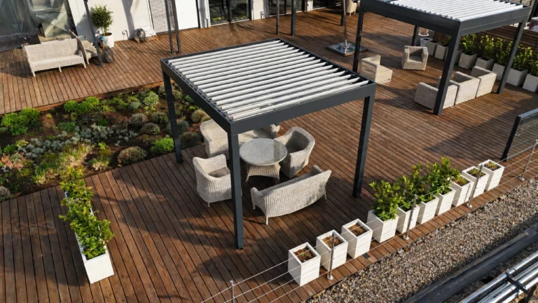 Moderní hliníková bioklimatická pergola na terase rodinného domu, s venkovním posezením u bazénu – elegantní spojení designu a komfortu